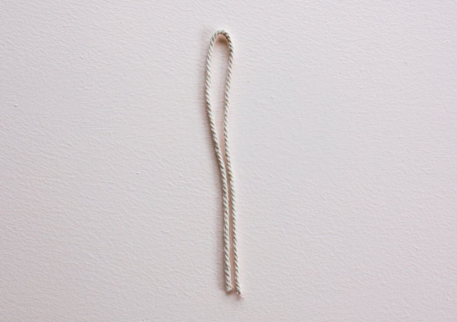 A doubled-over piece of string lies on the table.