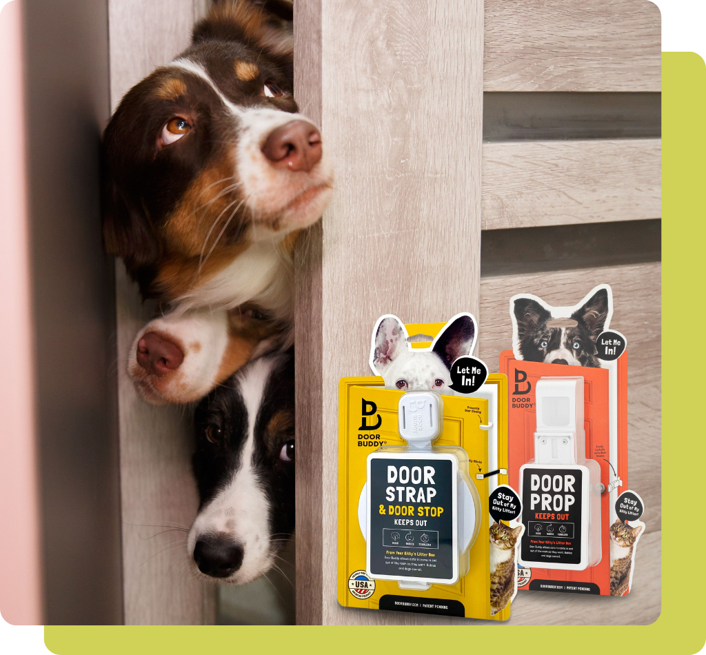 Two dogs peek through a slightly open door beside Door Buddy Door Strap and Door Prop product packaging. The image highlights the two simple solutions designed to let cats pass through while helping keep dogs and toddlers out of certain rooms.
