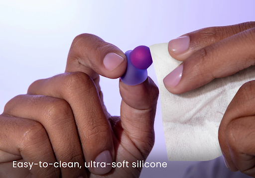 Hands holding a white cloth, cleaning the best earplugs for sleeping.