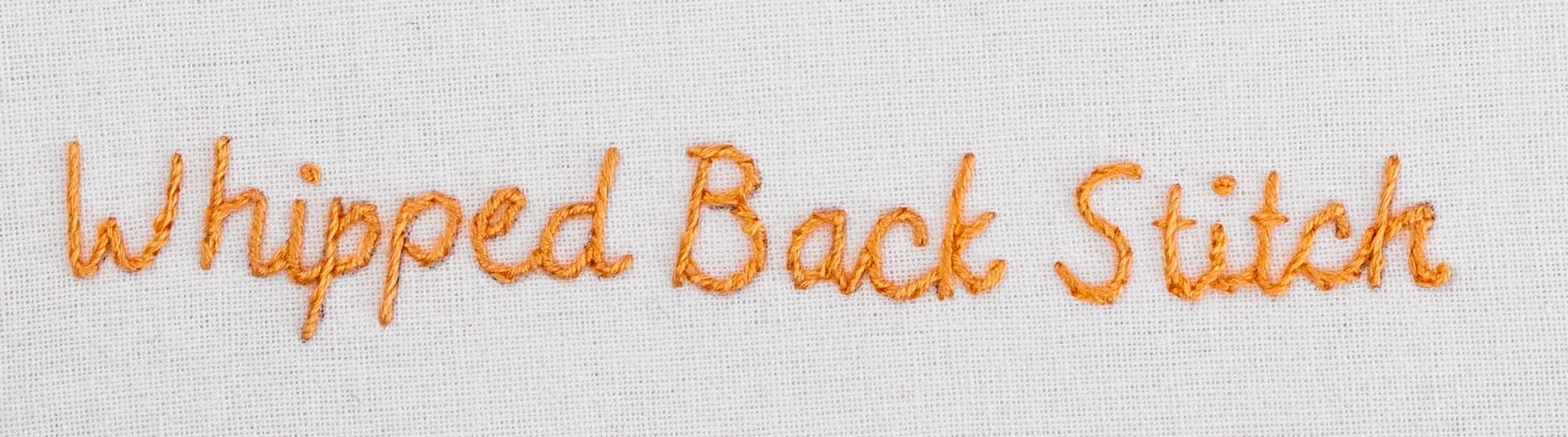 This is an image of a handwritten-looking script stitched in back stitch.