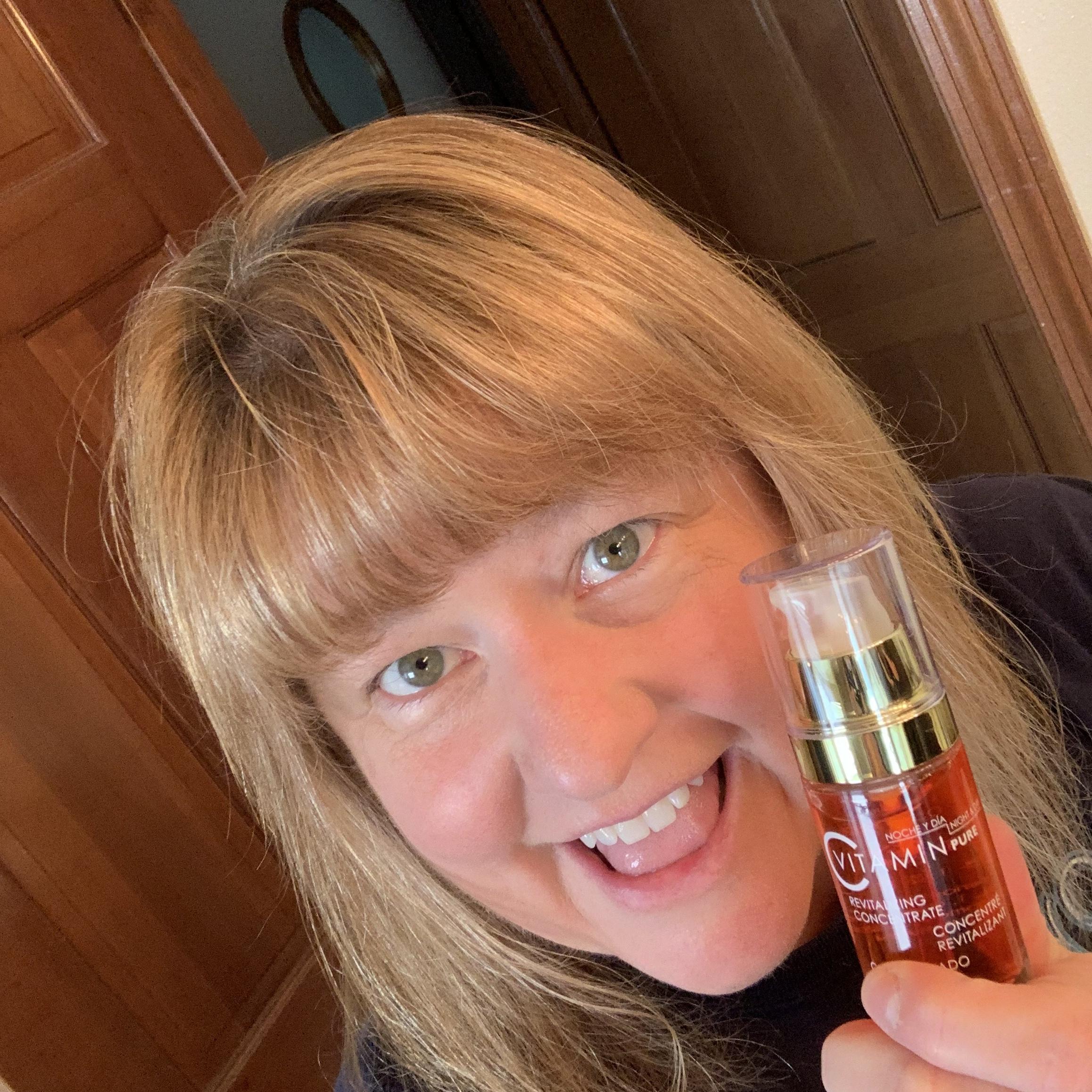 smiling customer holding Noche's Vitamin C Serum