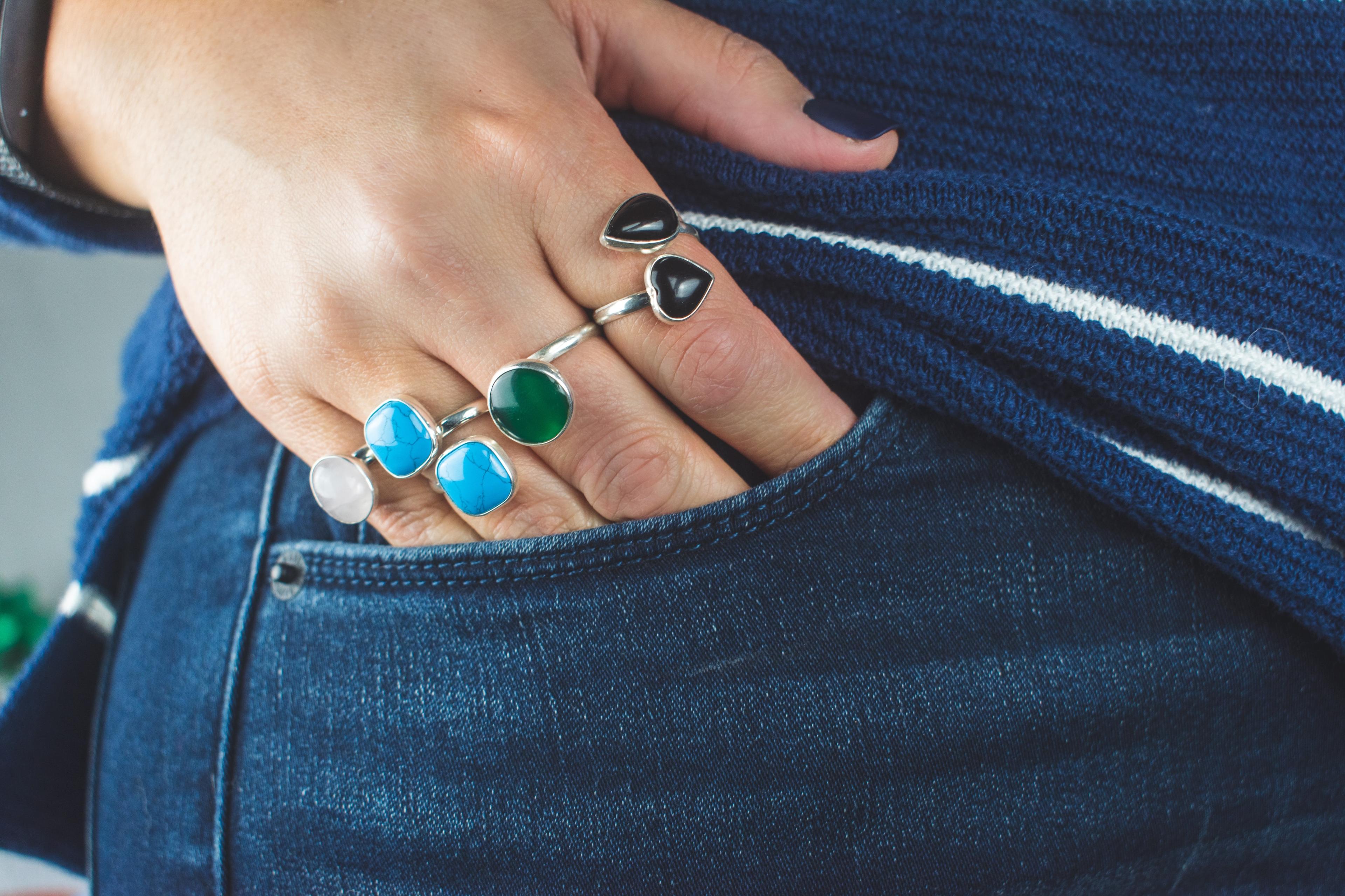 Hand in pocket wearing multiple rings.