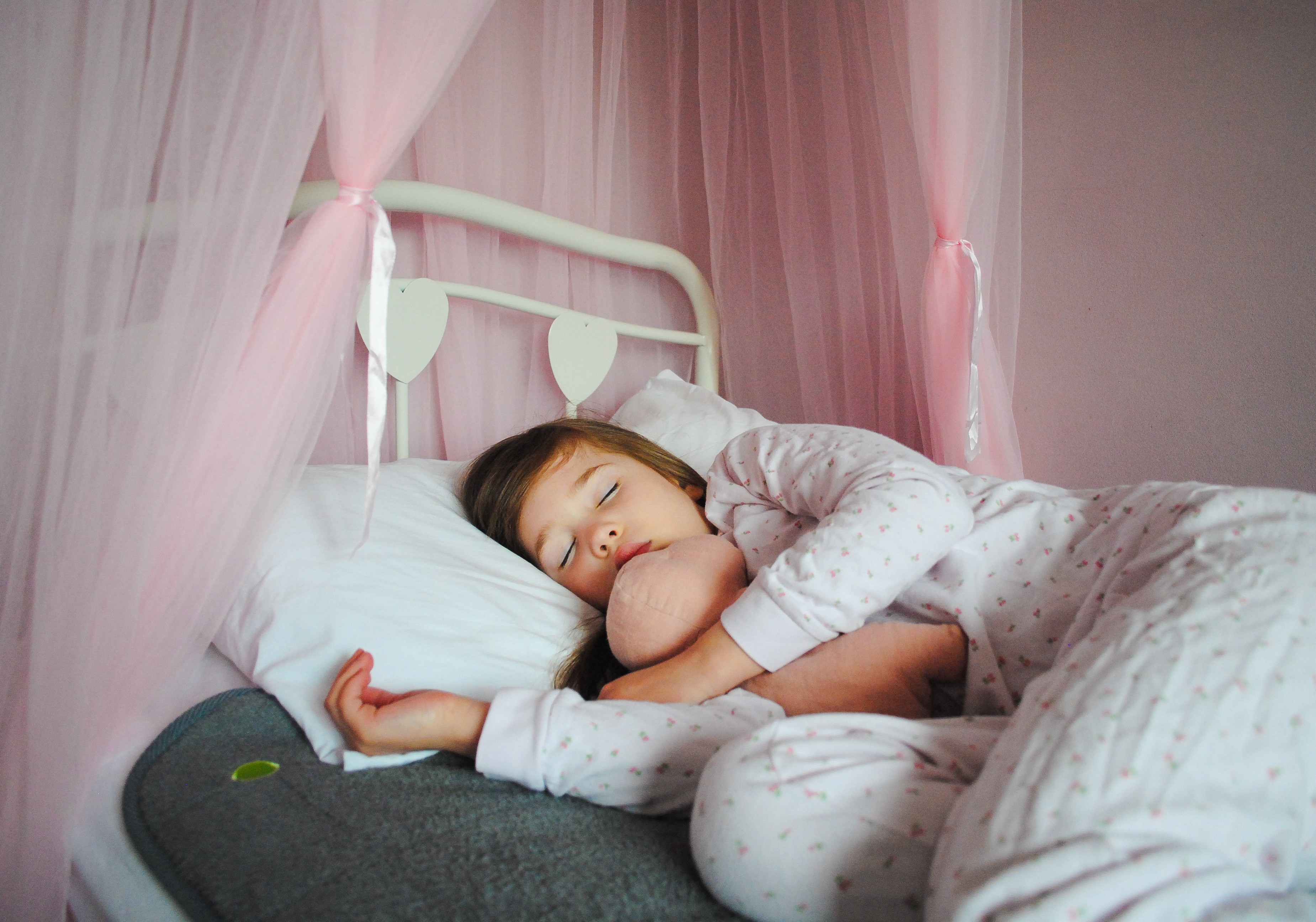 Girl lying in bed on PeapodMats