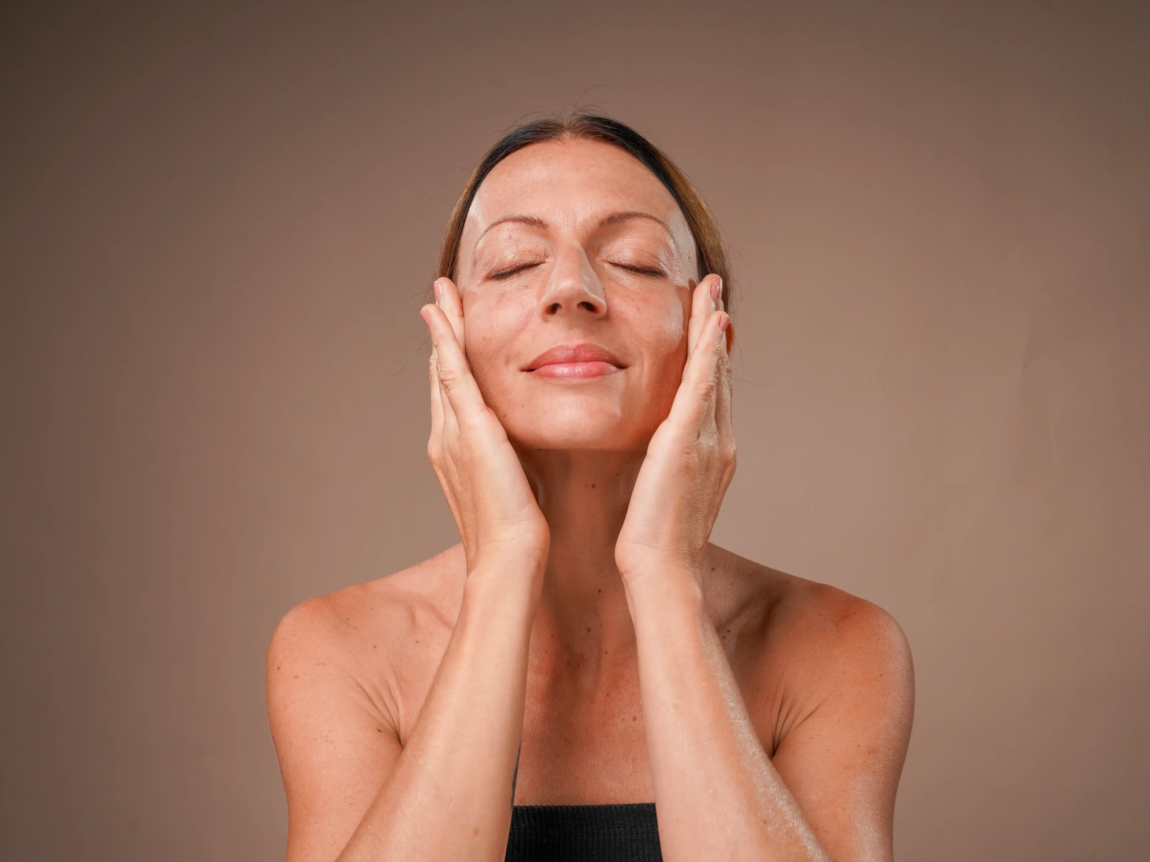 woman massaging her face and feeling relaxed