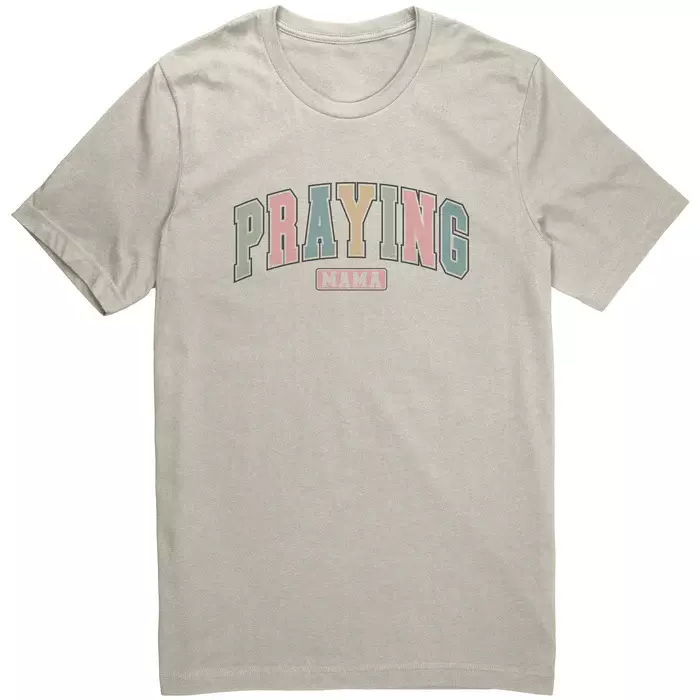 off white tee, text says in multi colored pastel print "Praying mama"