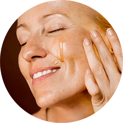 A woman looking happy and satisfied, using the serum