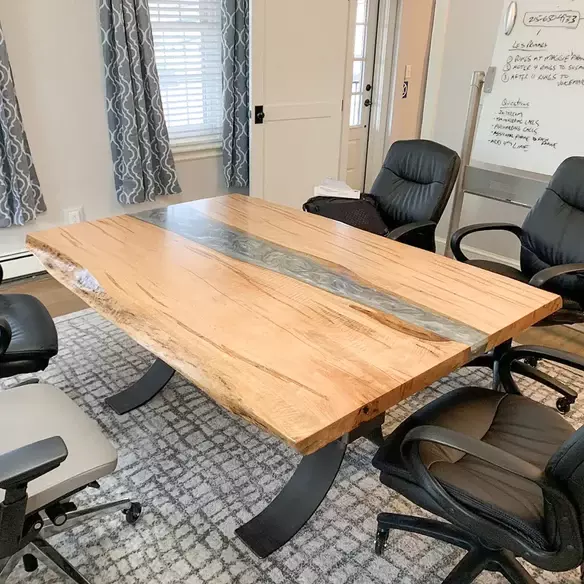 Spalted maple conference table with sleek gray epoxy river in bright meeting room