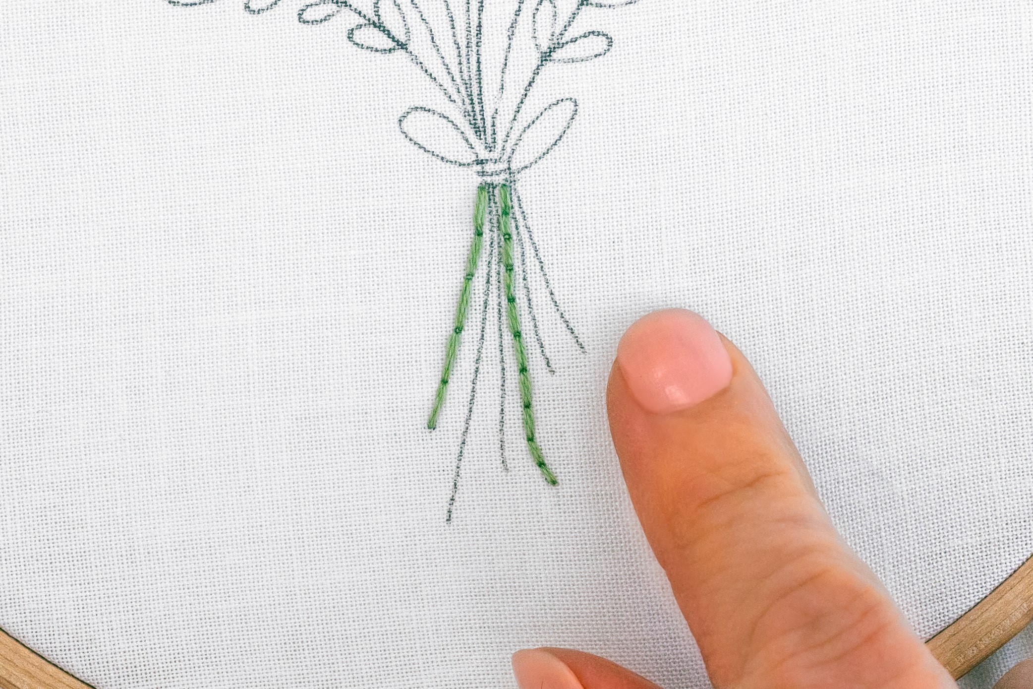 A finger points at the length of stitches for flower stalks.