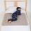 Toddler boy on the bed with sand medium PeapodMat - washable bed mat