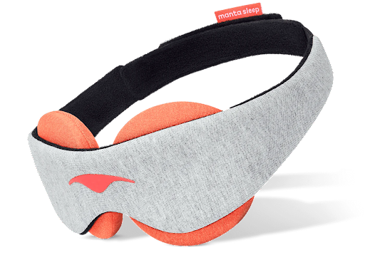 The gray head strap and orange eye cups of a warming sleep mask with beads.
