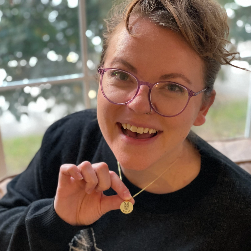 A woman wearing and showing off the CC Custom Necklace she bought.