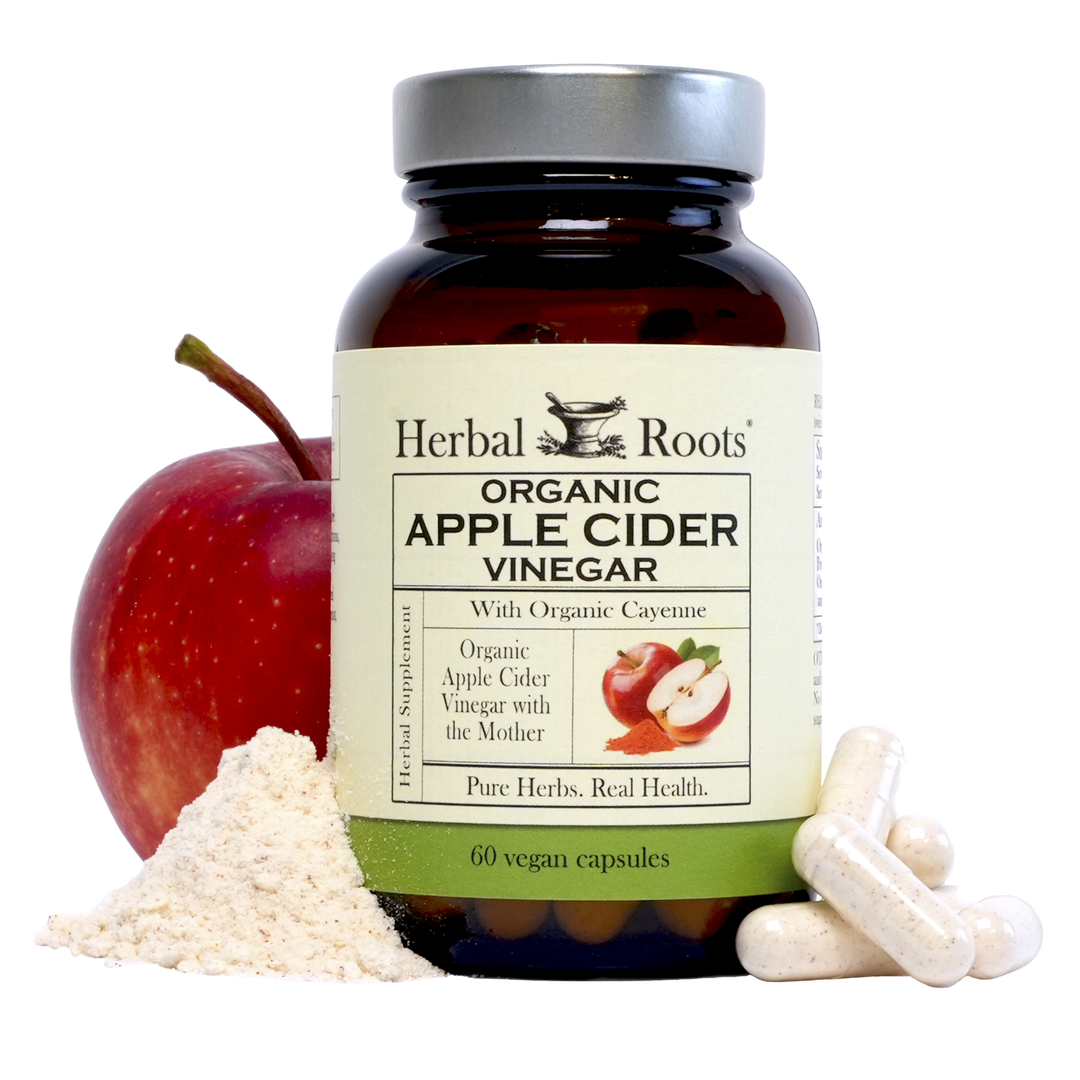 Bottle of Herbal Roots Organic Apple Cider Vinegar with capsules on the right of the bottle and a small apple peeking out from behind the bottle on the left with a small pile of ACV powder.