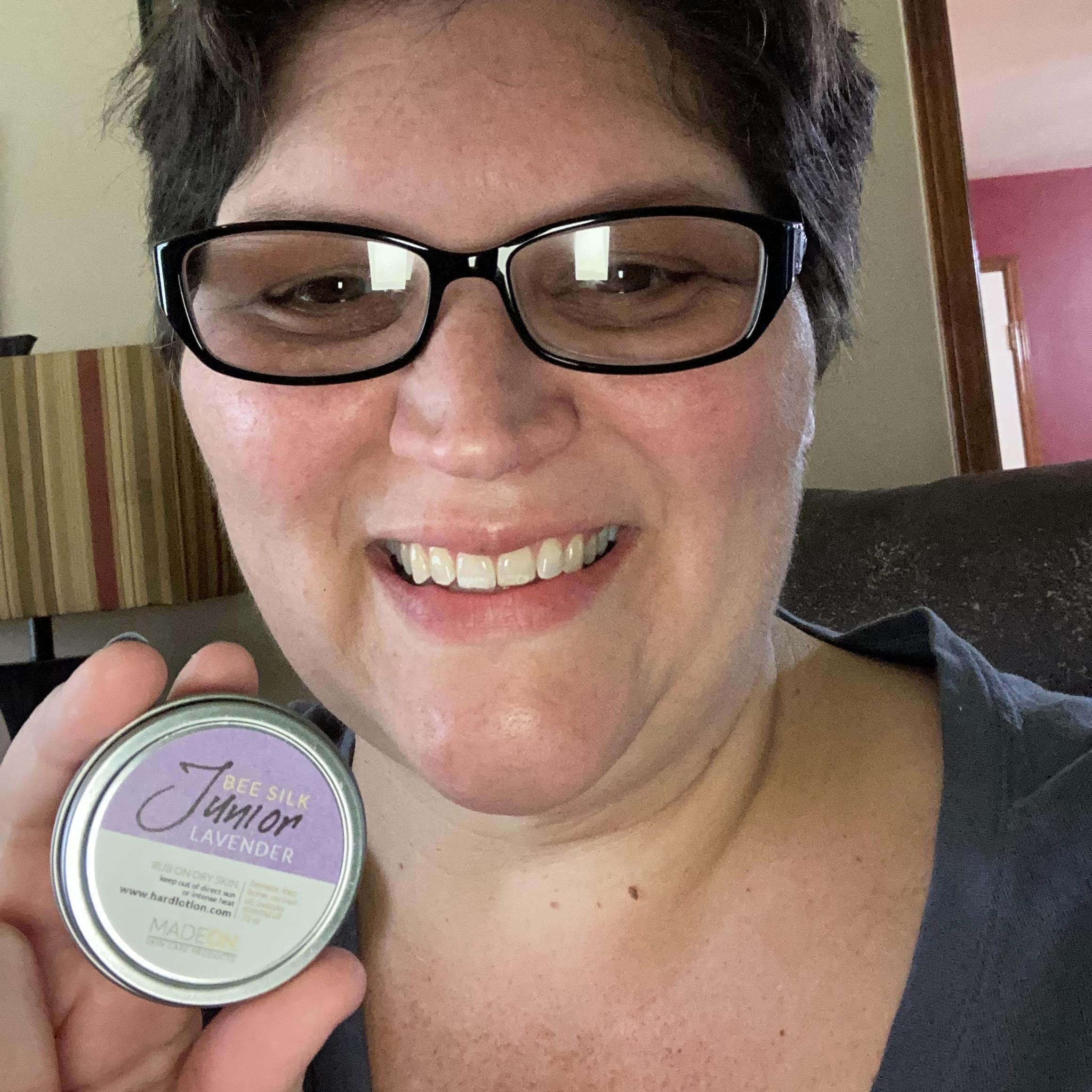 hands holding lavender lotion emollient