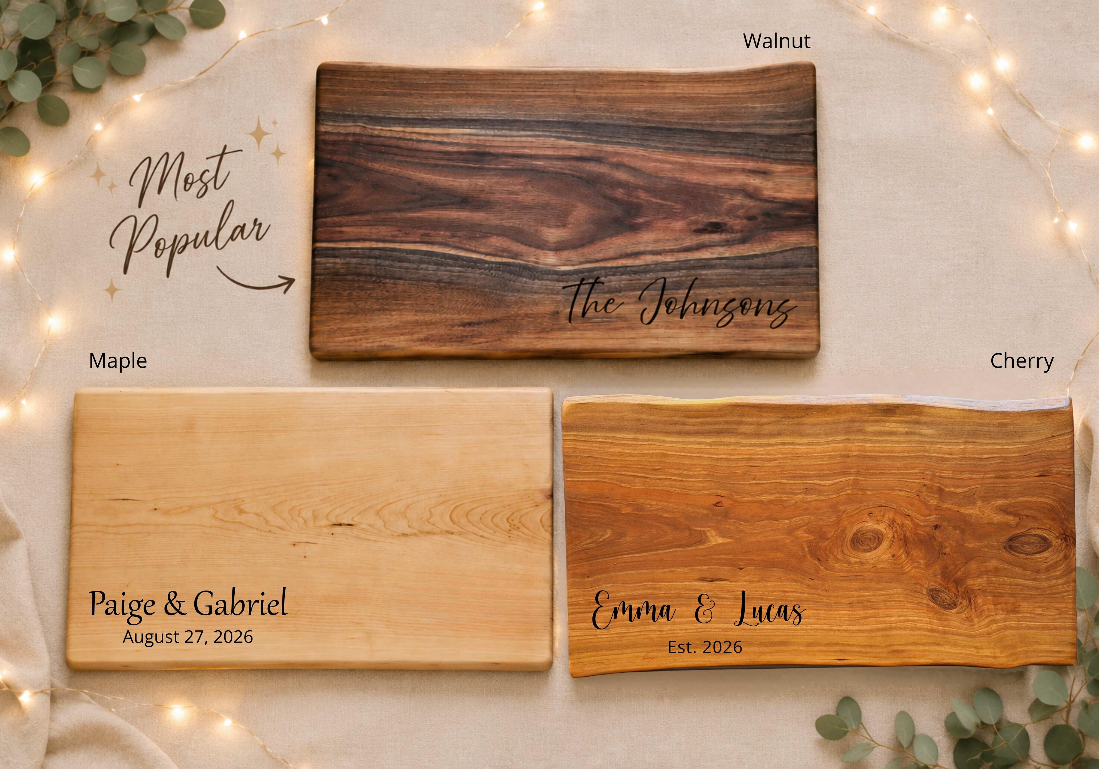 Wedding gift engraving inspiration featuring three personalized hardwood boards in walnut, maple, and cherry. The walnut board displays the most popular complimentary engraving style with “The Johnsons,” while the maple and cherry boards showcase additional wedding engraving ideas including couple names, wedding dates, and custom messages. Rustic elegant background with warm lighting and natural greenery accents.