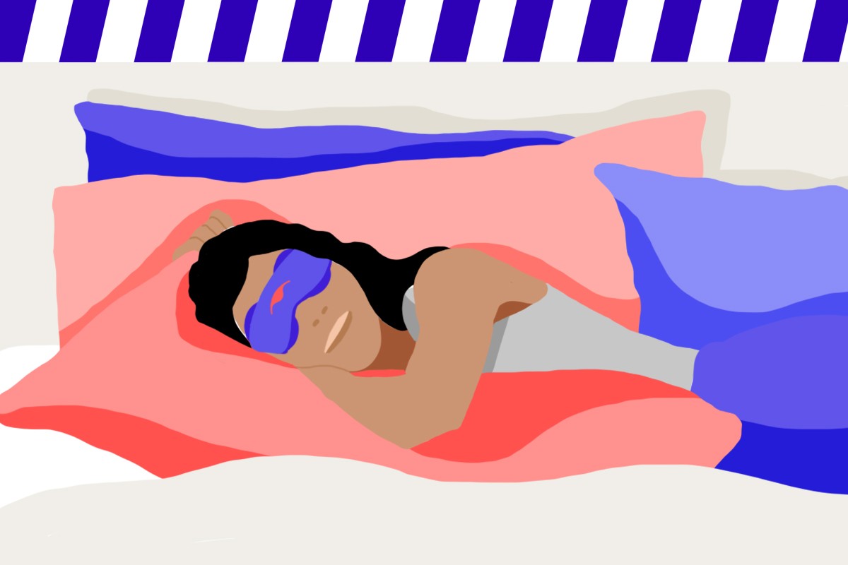 A girl sleeping on a bed wearing a blue silk eye mask with eye cups.