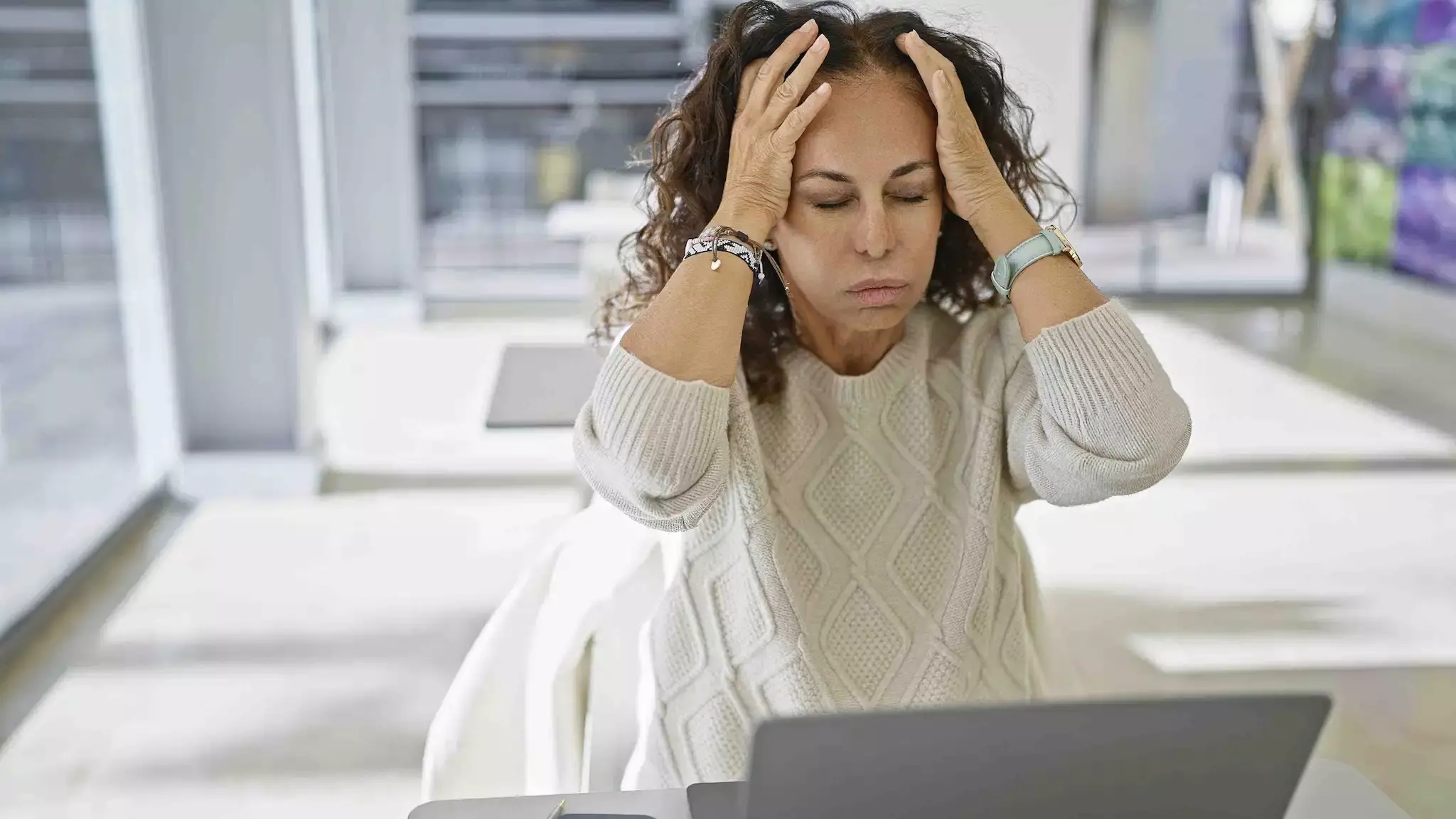 A lady sitting in front of her laptop struggling with eye strain