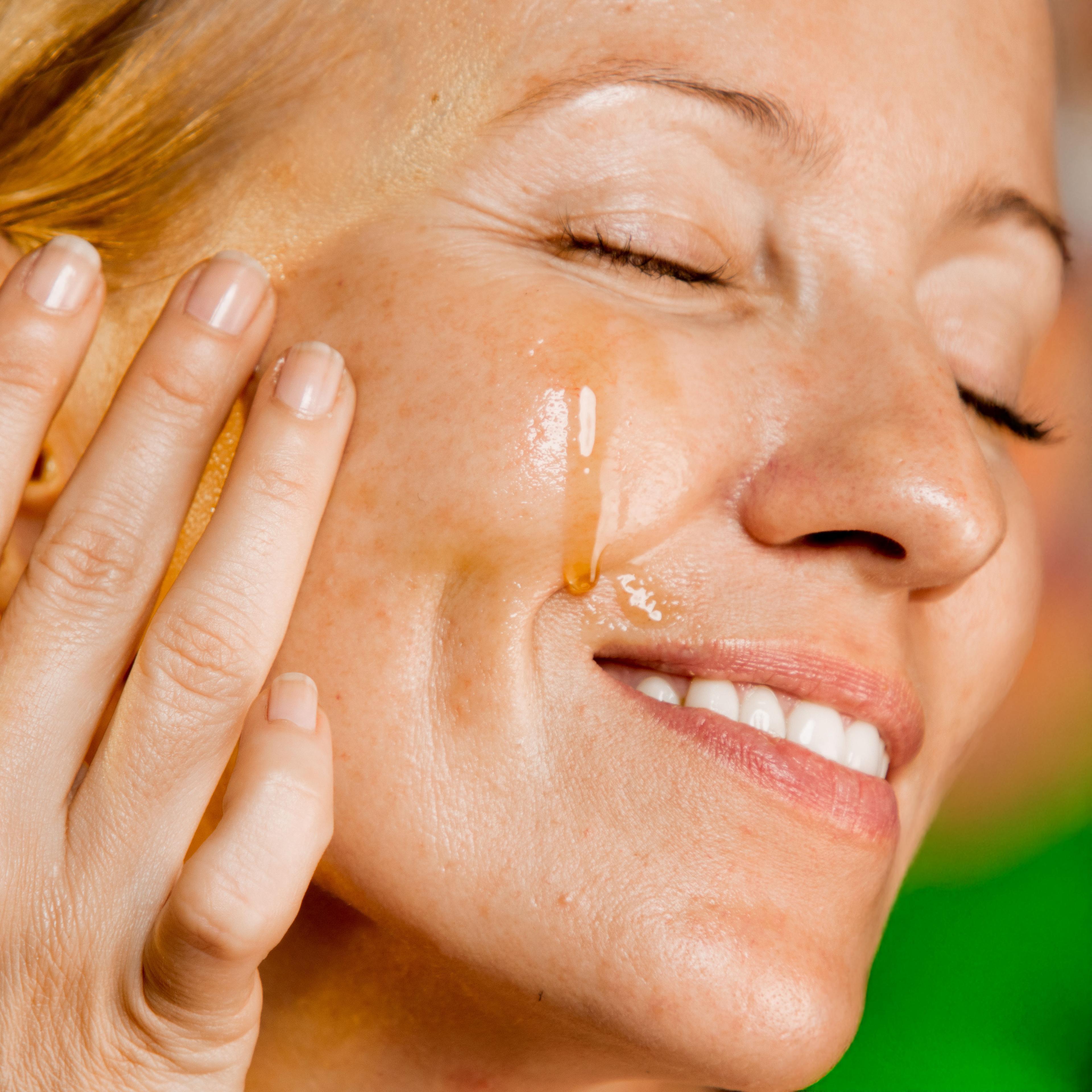 woman applying paraania oil on face