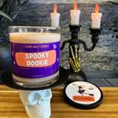 A beige spooky dookie stank away halloween candle on a spooky halloween background