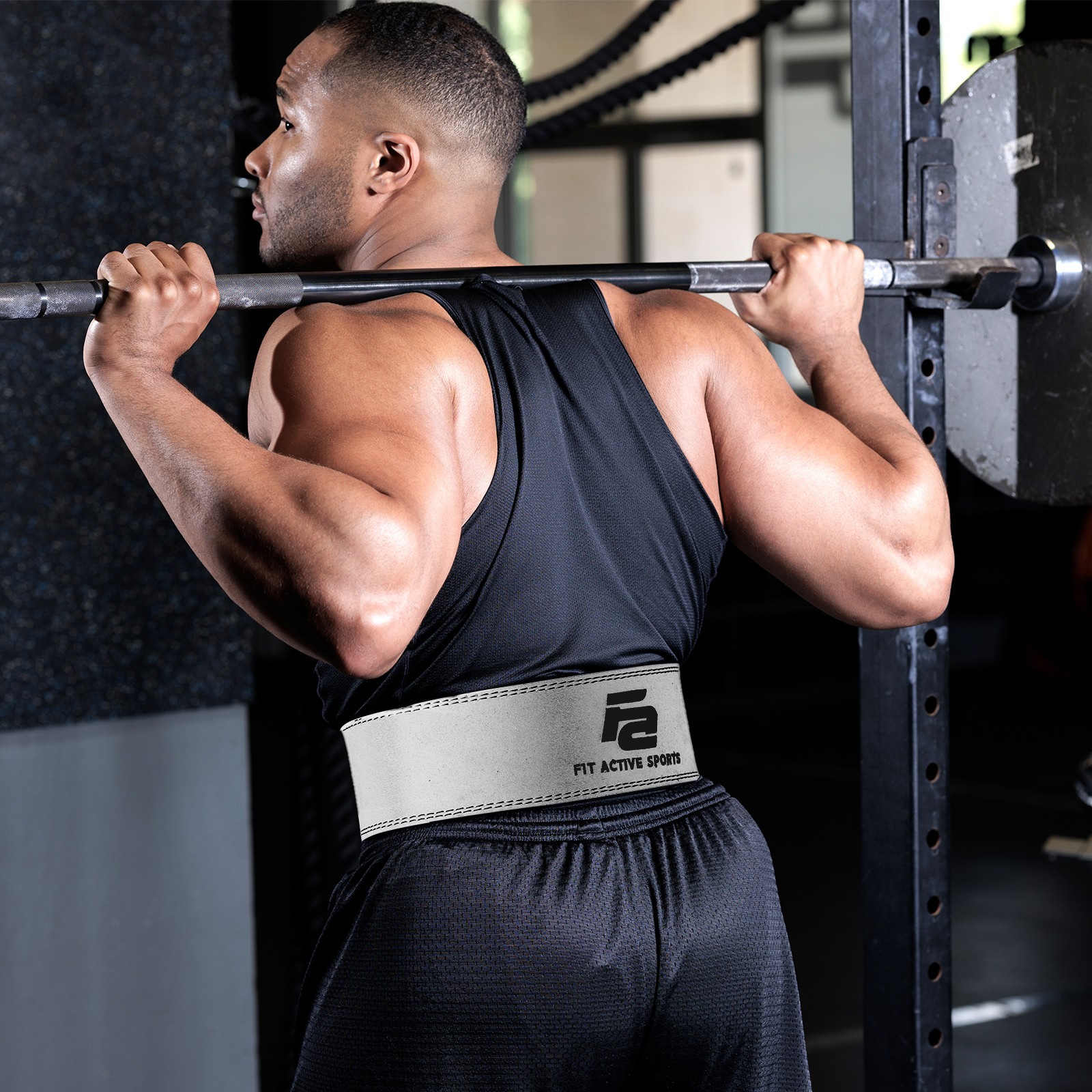 Man wearing grey lever belt preparing to squat with barbell