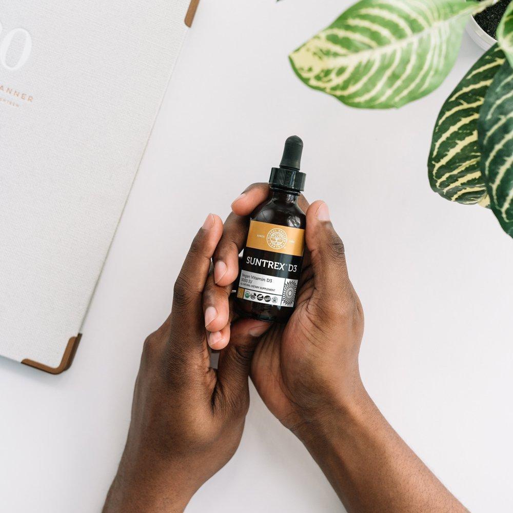 Global Healing Suntrex D3 Vegan Vitamin D3 Bottle In Hand