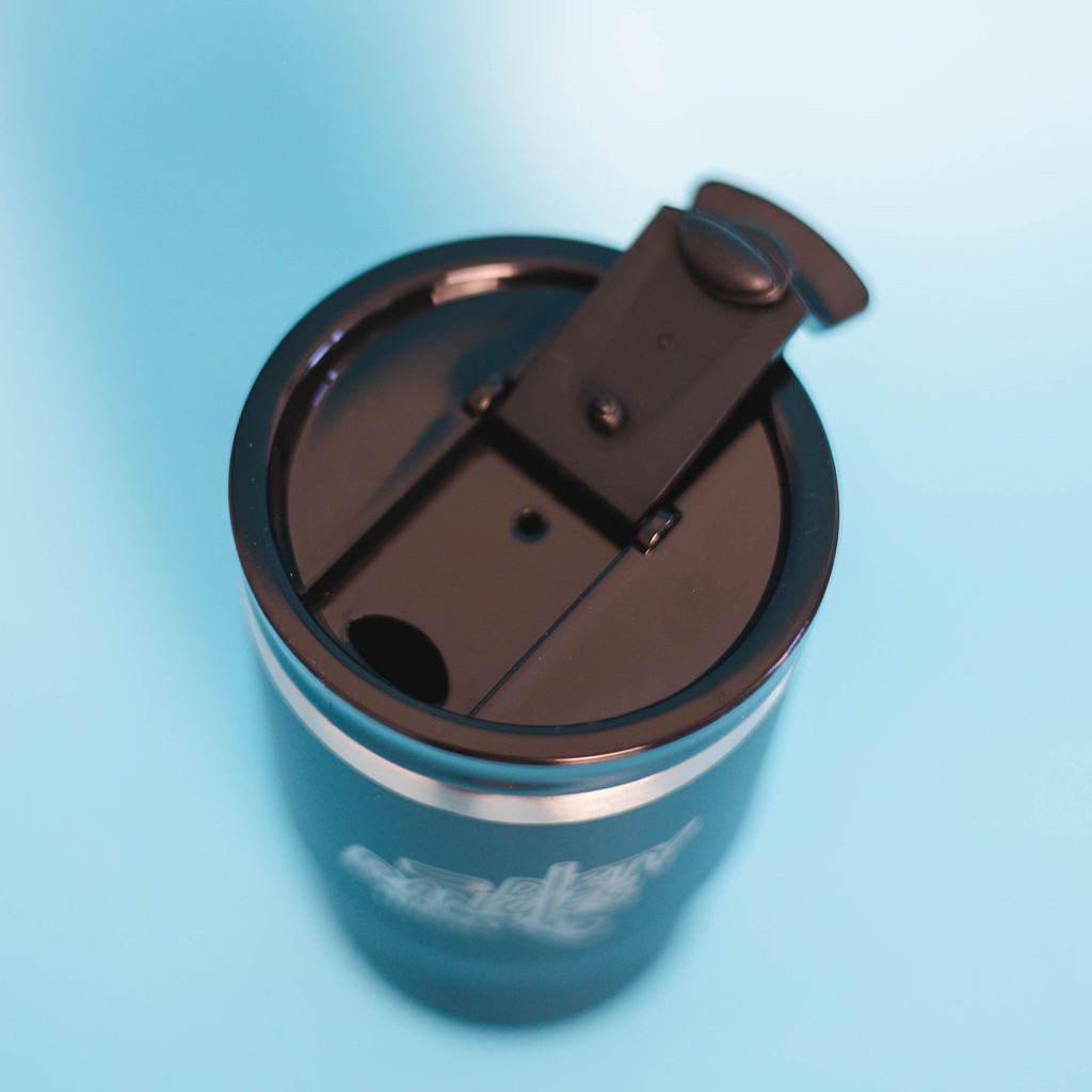A top down view of a black dirty dangles hockey 12 oz 4 in 1 tumbler drink cooler combo showing the standard tumbler lid