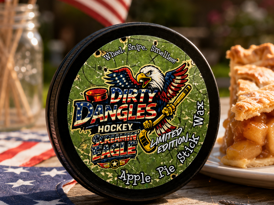 A tin of dirty dangles screamin eagle 4th of july stick wax on a picnic table with apple pie and american flags