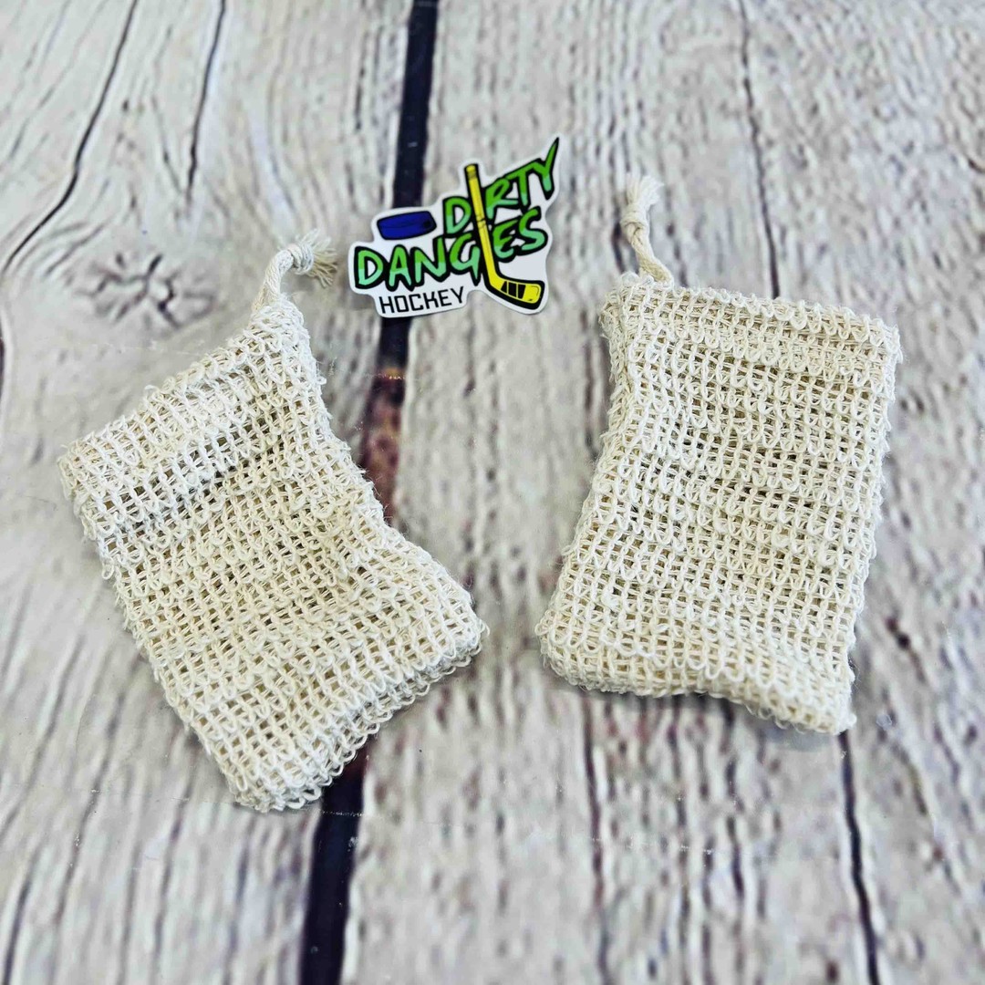 2 tan sisal soap bags on a wood background with a dirty dangles hockey sticker