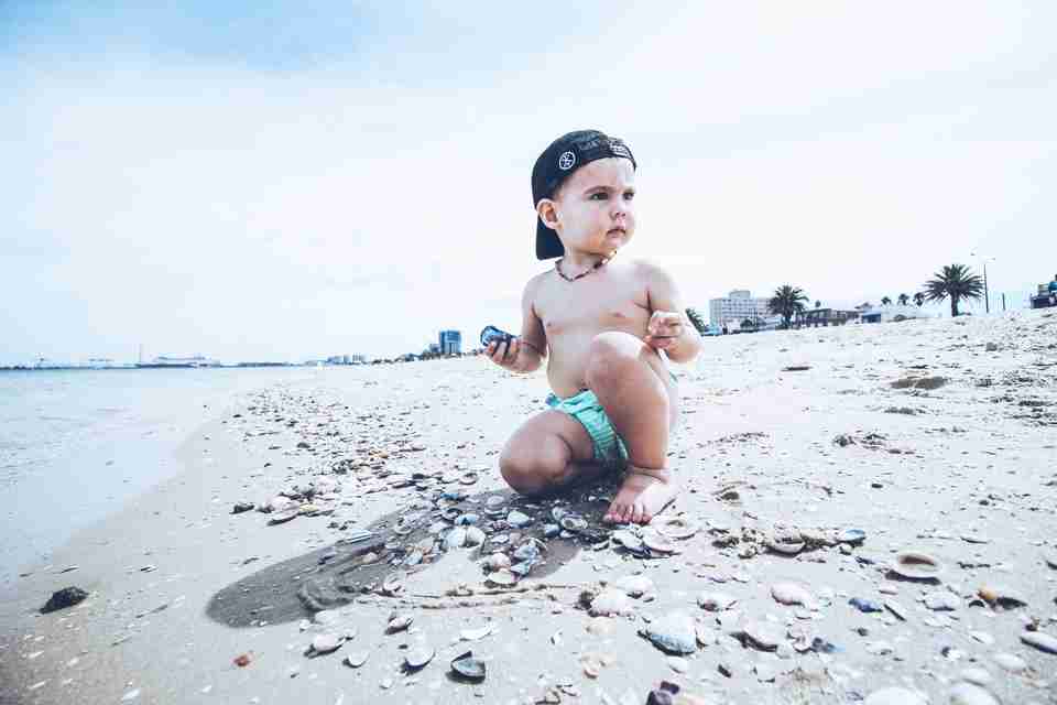 baby in the beach wearing reusable diaper
