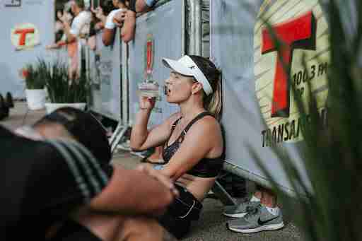 woman resting and hydrating drinking water after workout