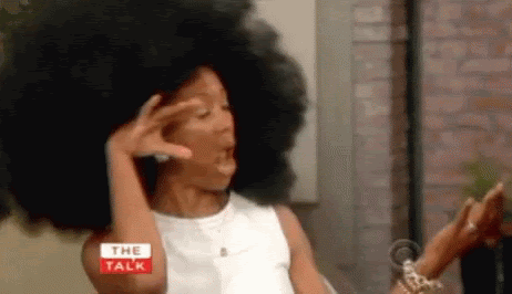 black woman flipping her heat damage free natural hair afro