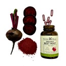 Aerial view of a whole beet with the stem with a small pile of beetroot powder and slices of beetroot to the right and a bottle of Herbal Roots Organic beetroot supplement laying face up with some capsules spilling out of the top