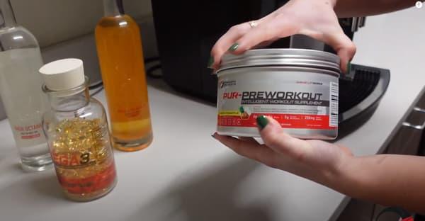 Hand Holding Preworkout Drink Fish Oil MCT Oil