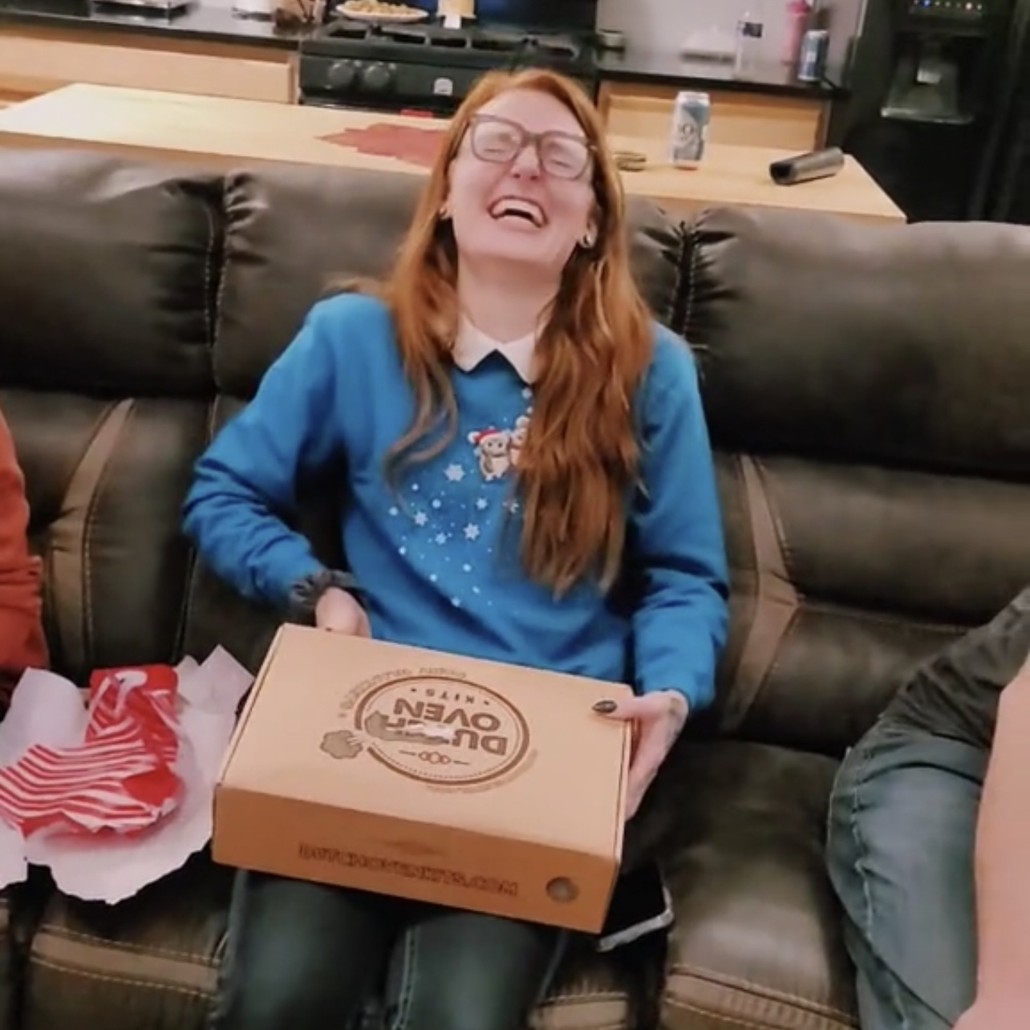 A woman laughing after opening a dutch oven kits gift box