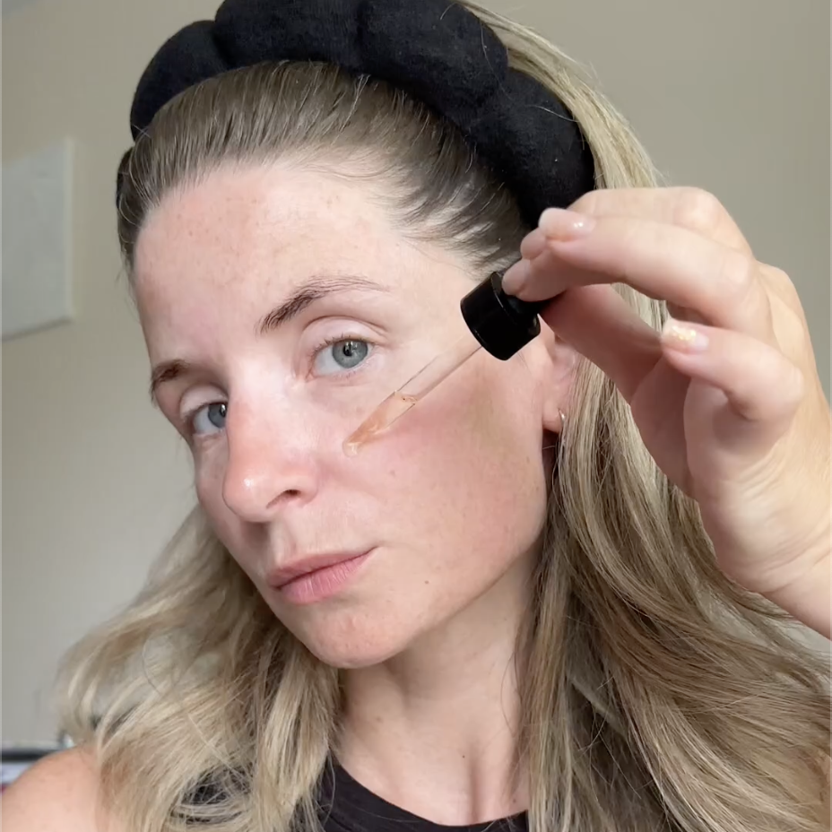 woman applying serum to her face after microneedling