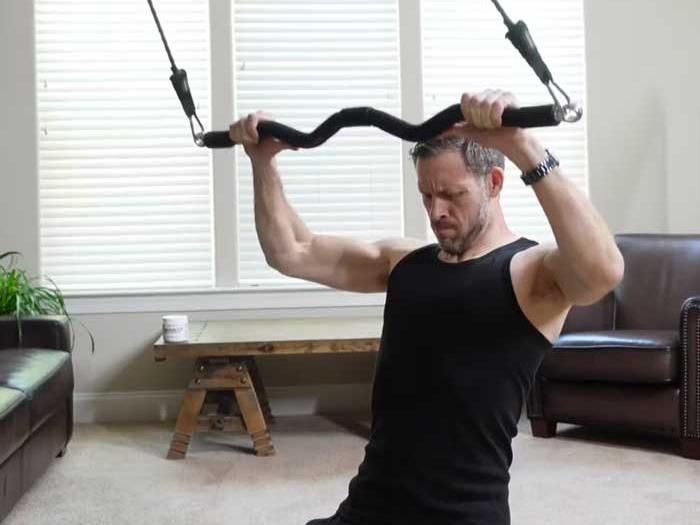 man using xbar to perform a lat pull down