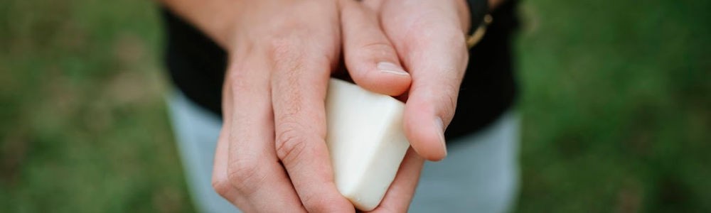 hands holding a solid hard lotion bar