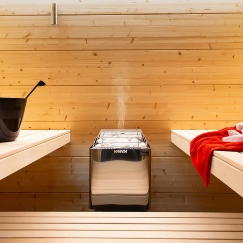 Water being poured over hot sauna rocks to create steam