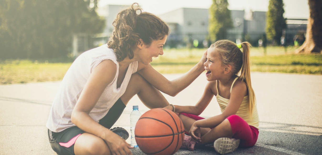 Mom with daughter playing basketball