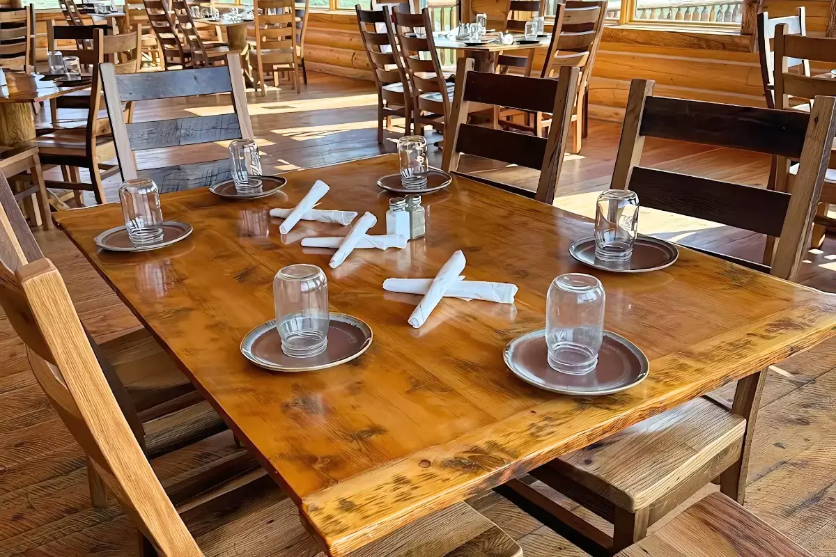 Reclaimed barnwood dining table surrounded by Akron chairs at Yellowstone restaurant