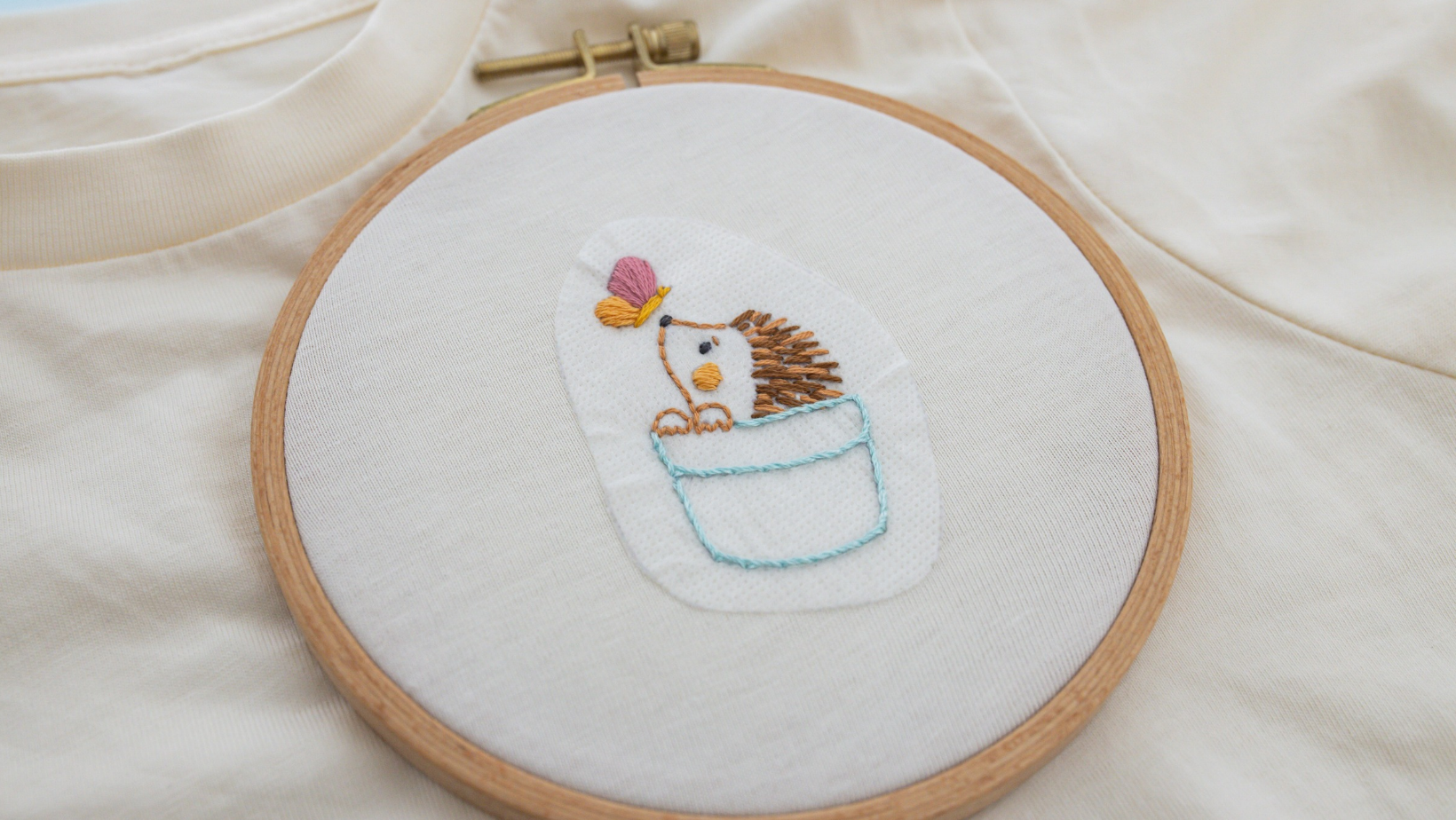 Hedgehog in pot plant wash away sticker stitche.d within hoop on t-shirt
