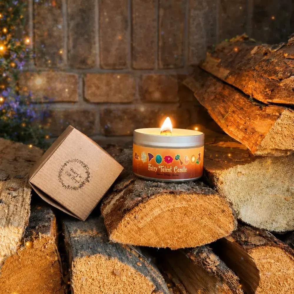 Fairy Talent Reveal Candle on top of some wooden logs next to a gift box.