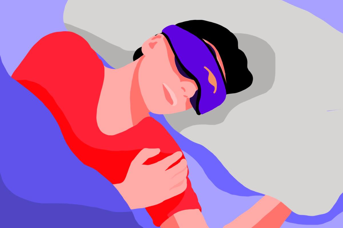 A sleeping man wearing a blue silk contour sleep mask with eye cups.