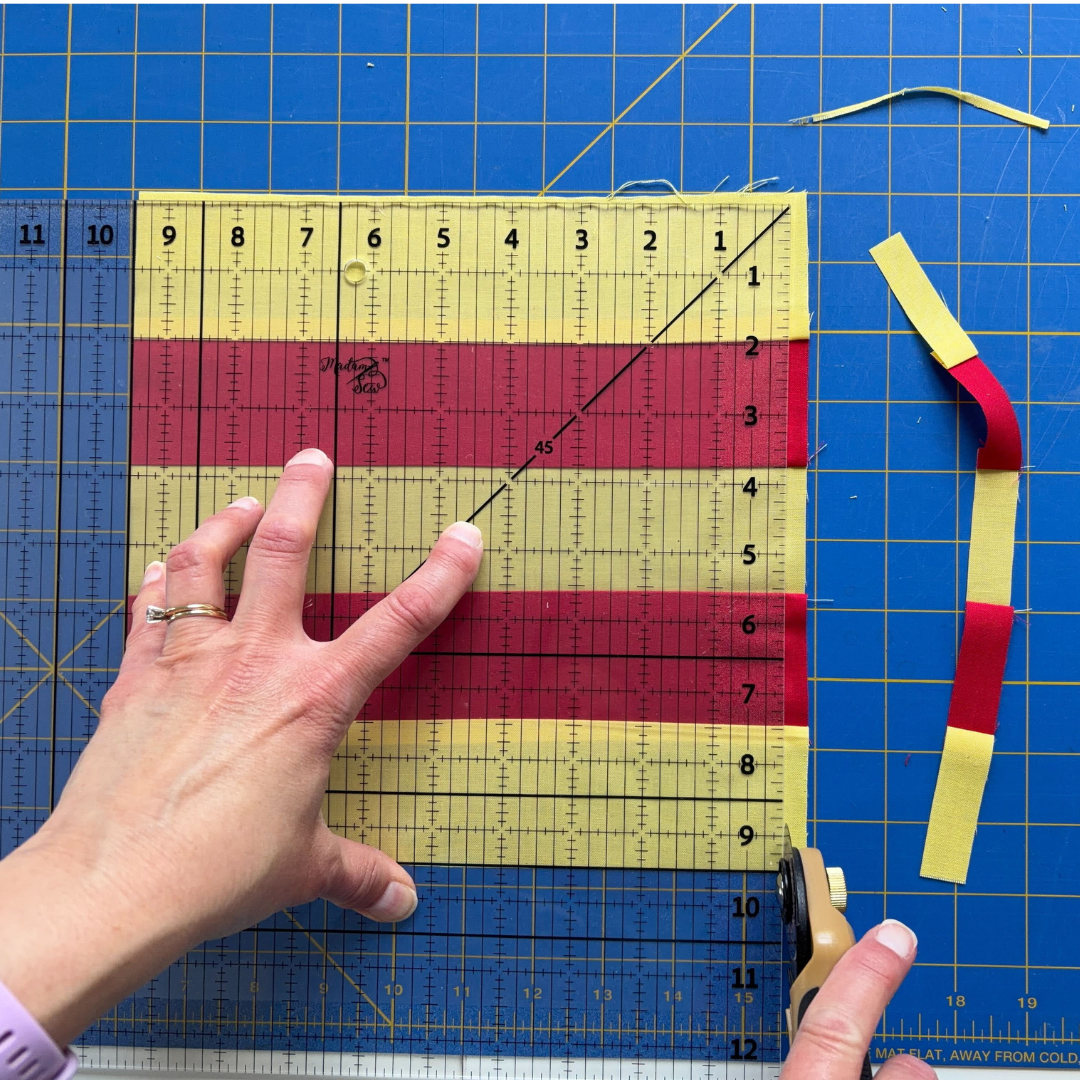 Cutting along the right edge of the Madam Sew 12.5” Square Up ruler while the opposite block edge is aligned on the 9.5” line.