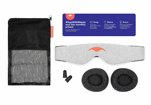 Counter-clockwise from left: A black mesh storage bag, blue instructions sheet, a gray head strap of a sleep mask, 2 dark gray convex eye cups, a pair of black earplugs.