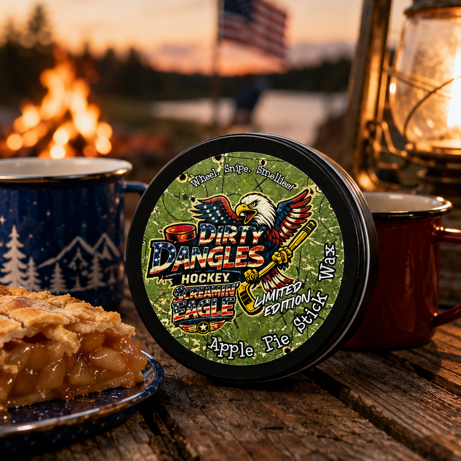 A tin of dirty dangles screamin eagle 4th of july stick wax on a picnic table with apple pie and american flags