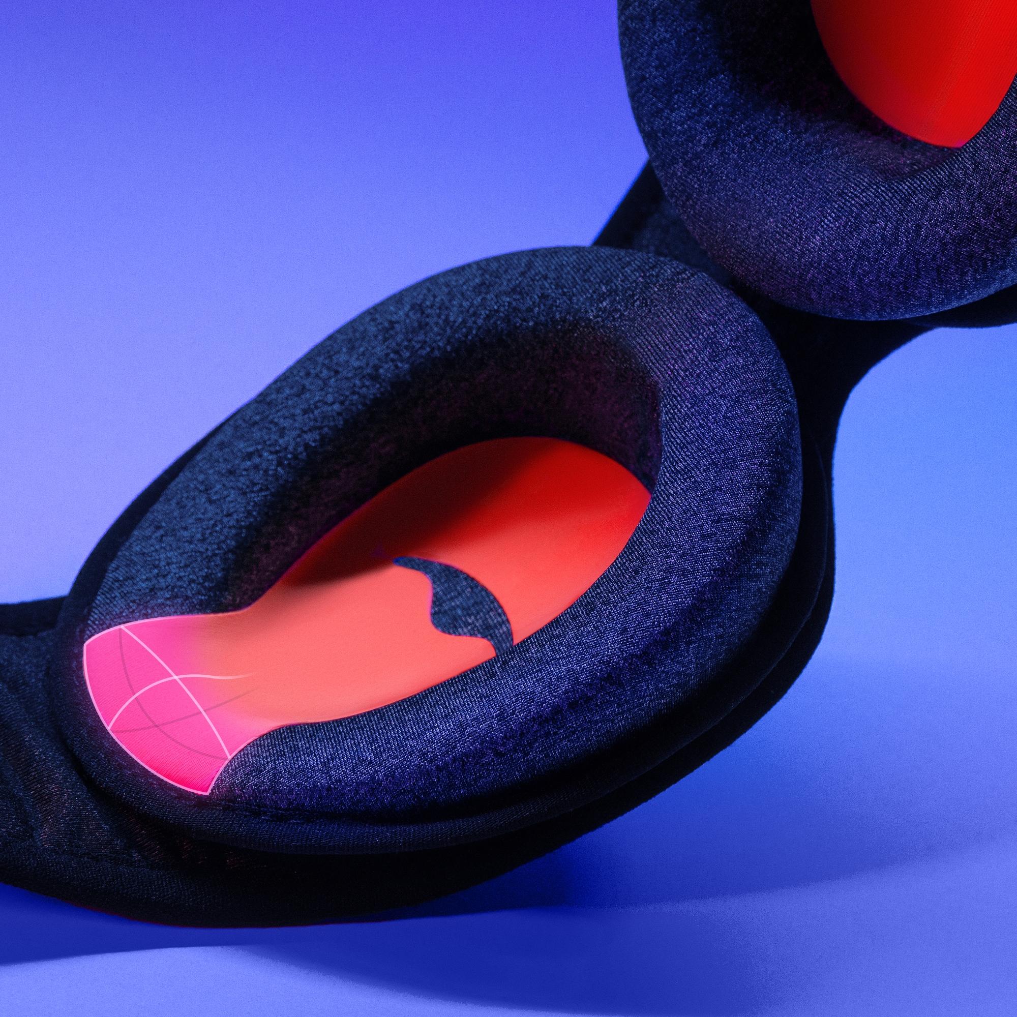 A black and orange C-shaped eye cup a sleep mask with a smart air bubble on the tapered end.
