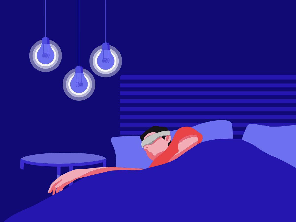 A guy lying down in bed wearing a sleep mask with light bulbs hanging over his head.