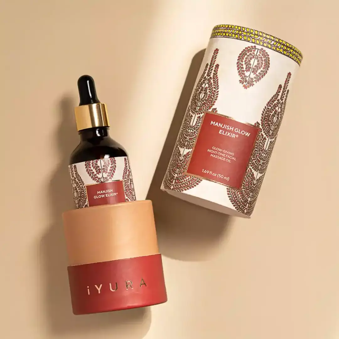 A bottle of manjish glow exilir showcased in its cylindrical packaging