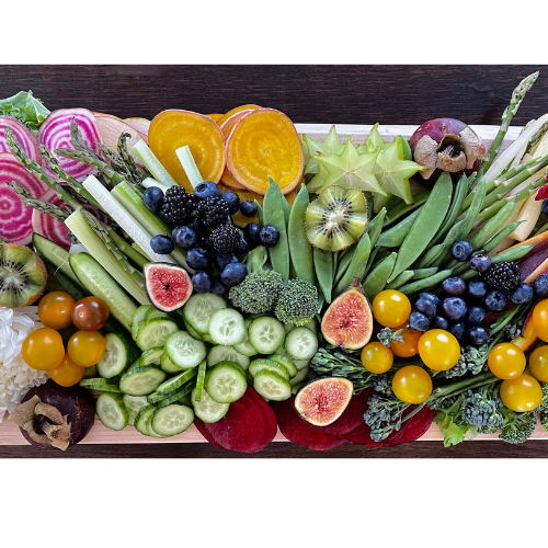 A beautiful colourful display of food on a maple live edge charcuterie board