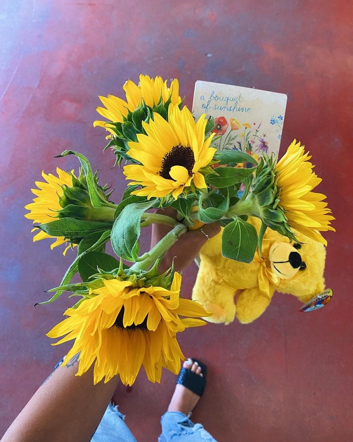 A bouquet of yellow flowers and a yellow bear
